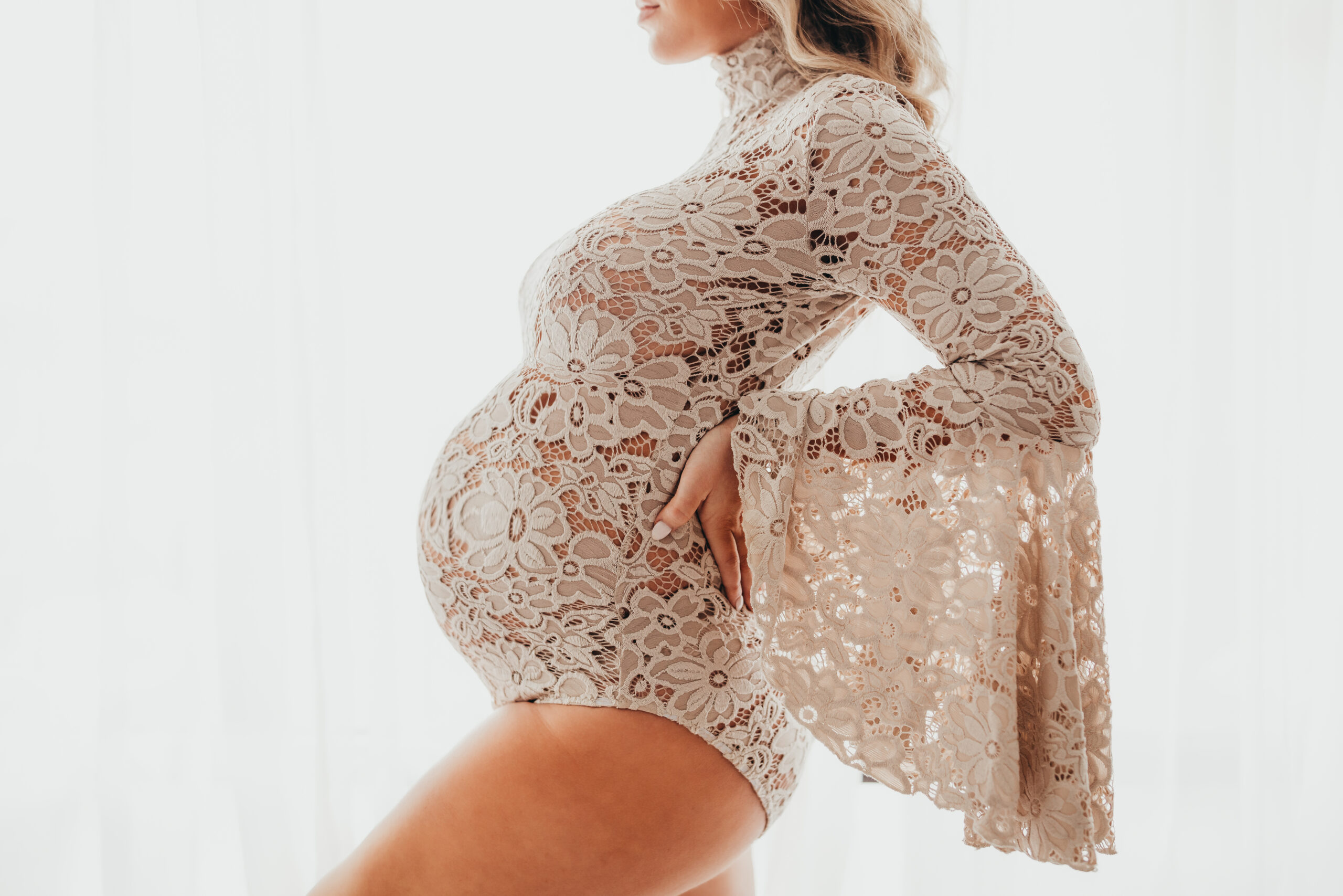 Expectant mama wearing a boho bodysuit similar to styles found in many Houston Maternity Stores.