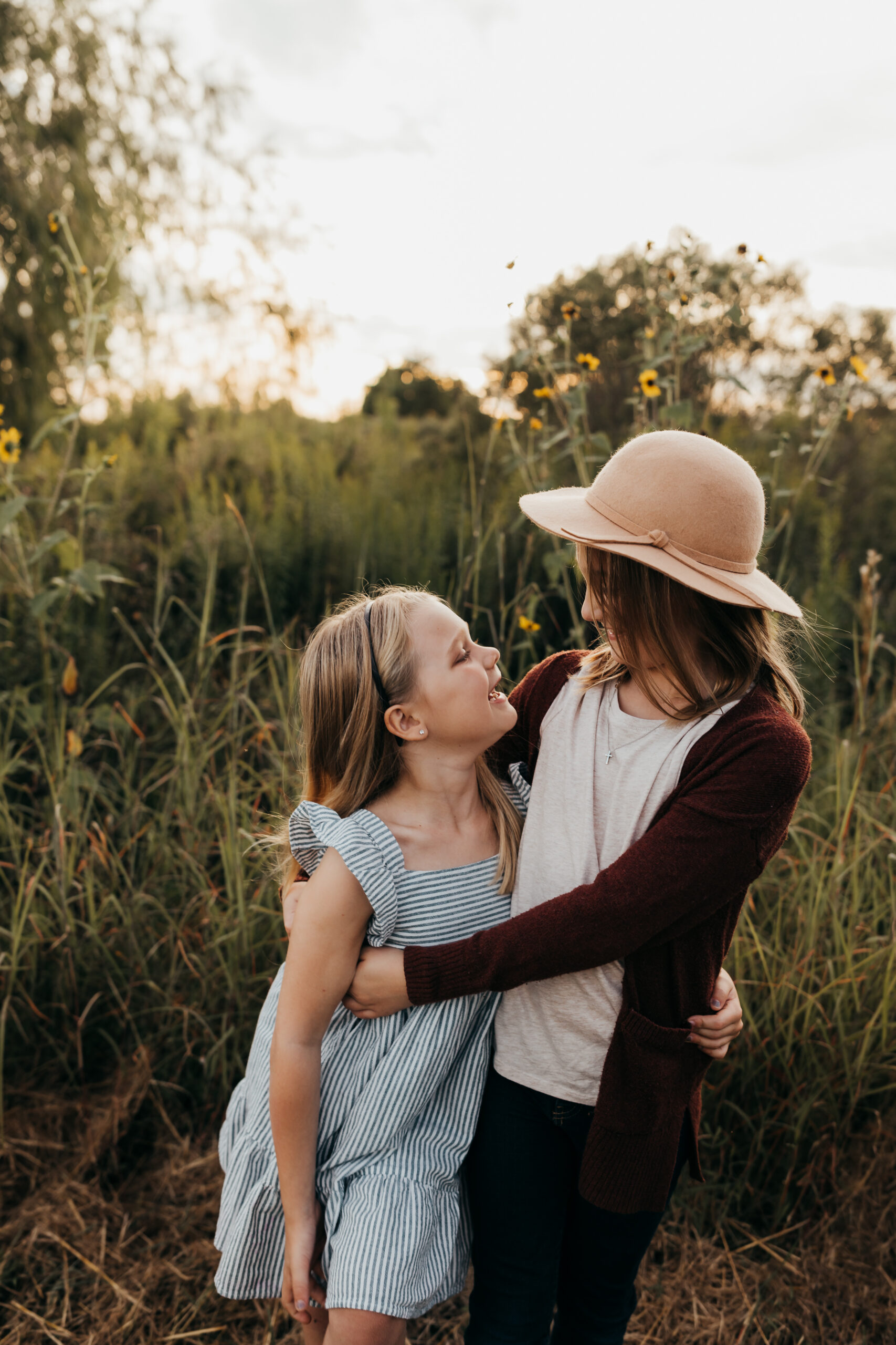 Sisters hugging each other gently during a golden hour session with Ally's Photography