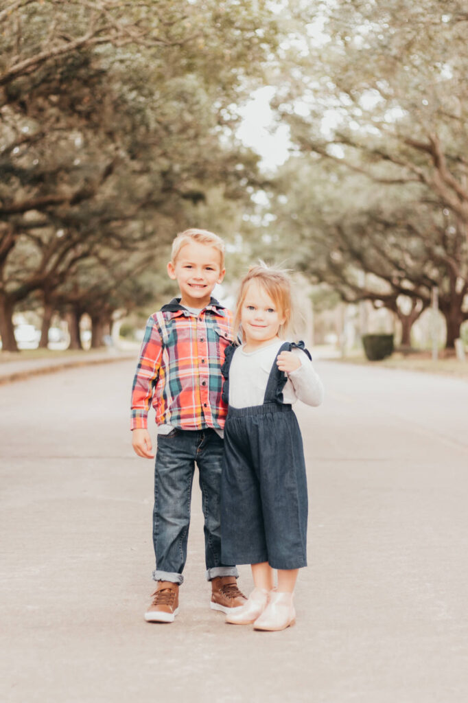 Brother & Sister pose in middle of street sporting boutique style outfits for Motherhood session