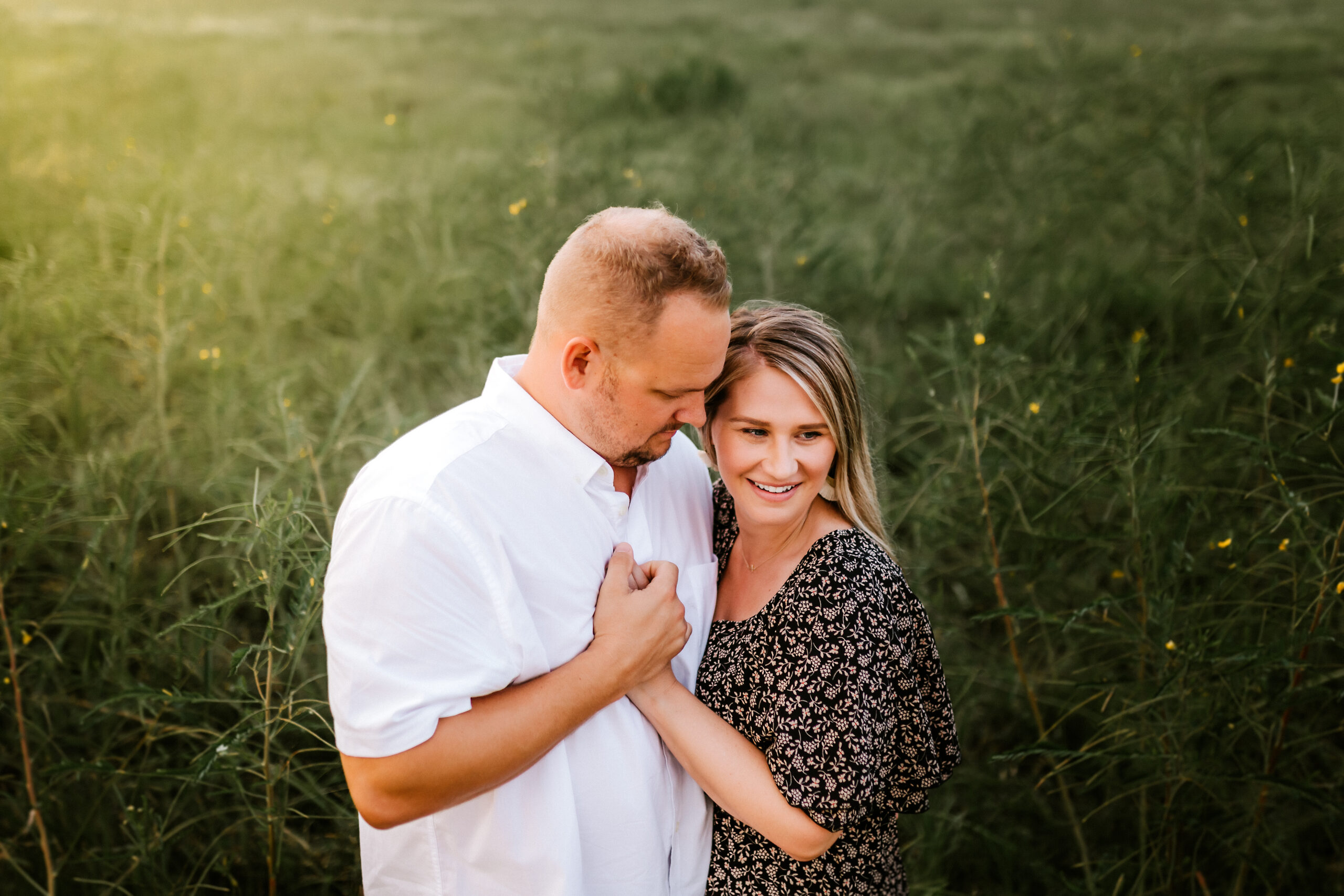 Ally's Photography writes blog for romantic Galveston Getaway, standing in a field with her husband.