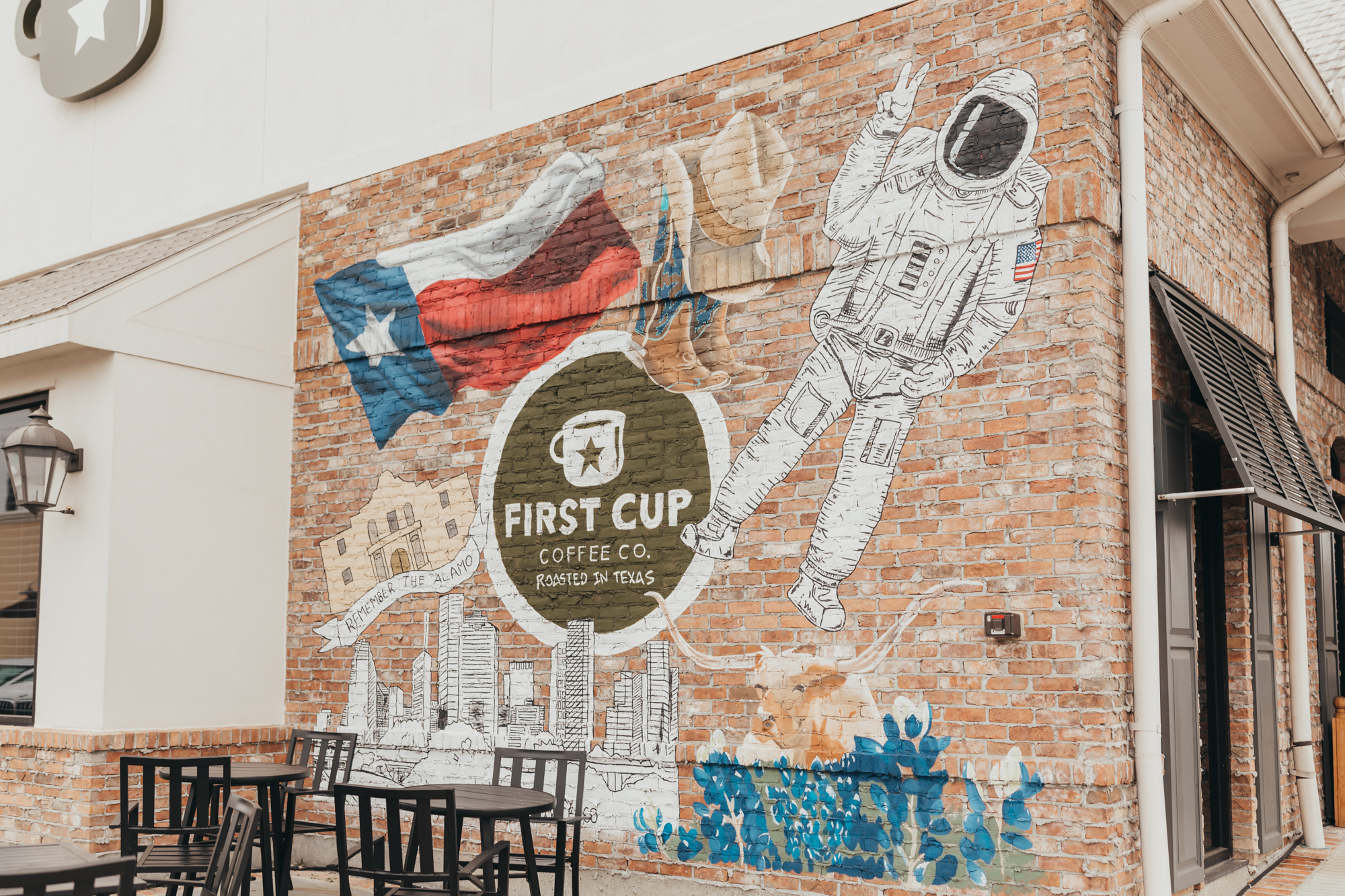 First Cup Coffee wall mural has notable images of Texas, including bluebonnets, NASA tributes, longhorns, the Alamo, and the skyline.