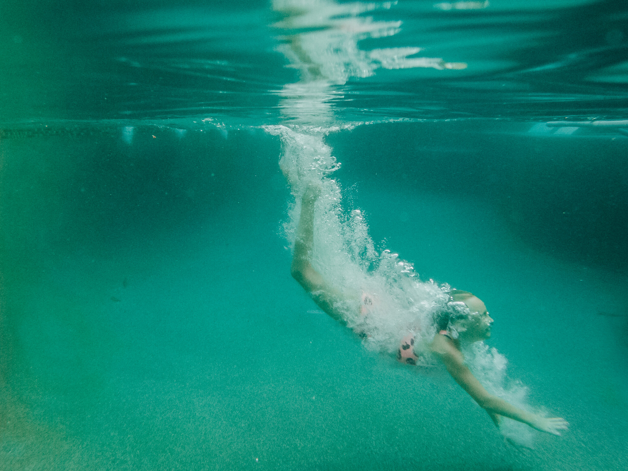 Child swimming under water, a skill taught by Houston Swim Lessons facility, Coastal Swim Academy.