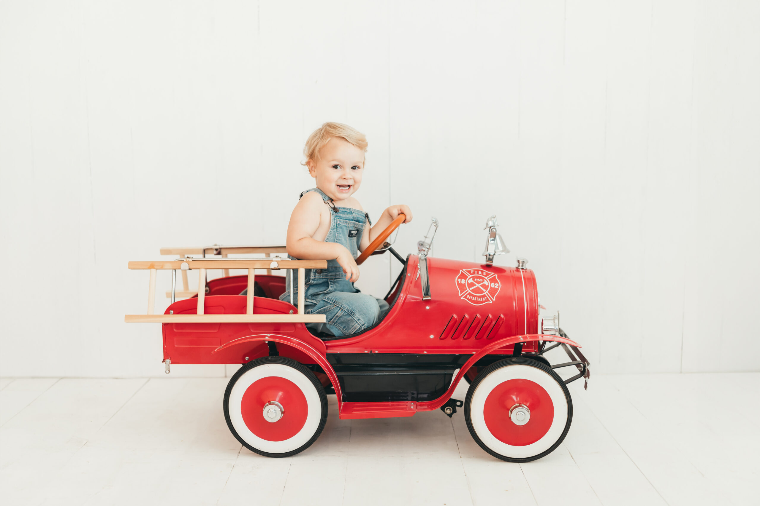 Little boy in firetruck in studio for Ally's Photography