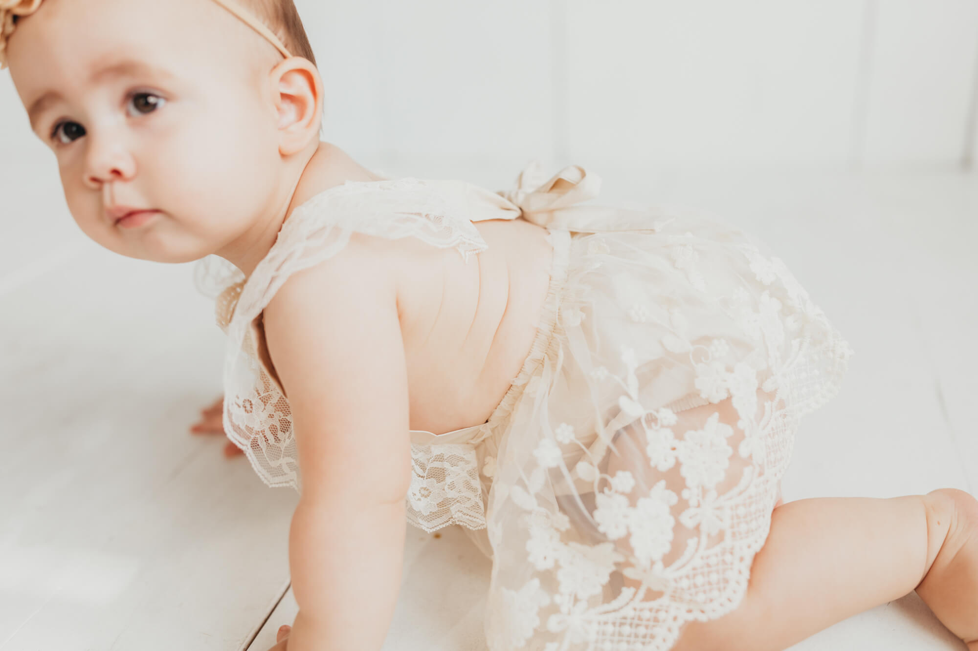Baby girl crawling during her first birthday photos by Allyson Blankenburg.