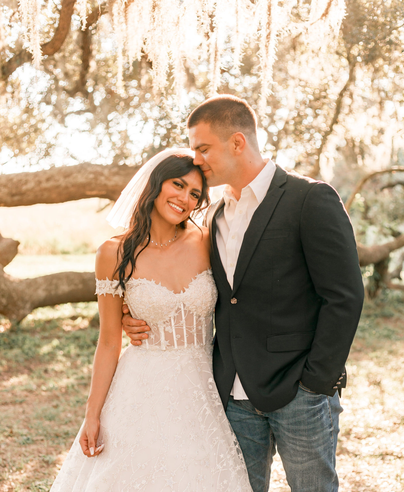 husband kisses wife on the forehead at their houston elopement with Ally's Photography, at brazos bend Park.